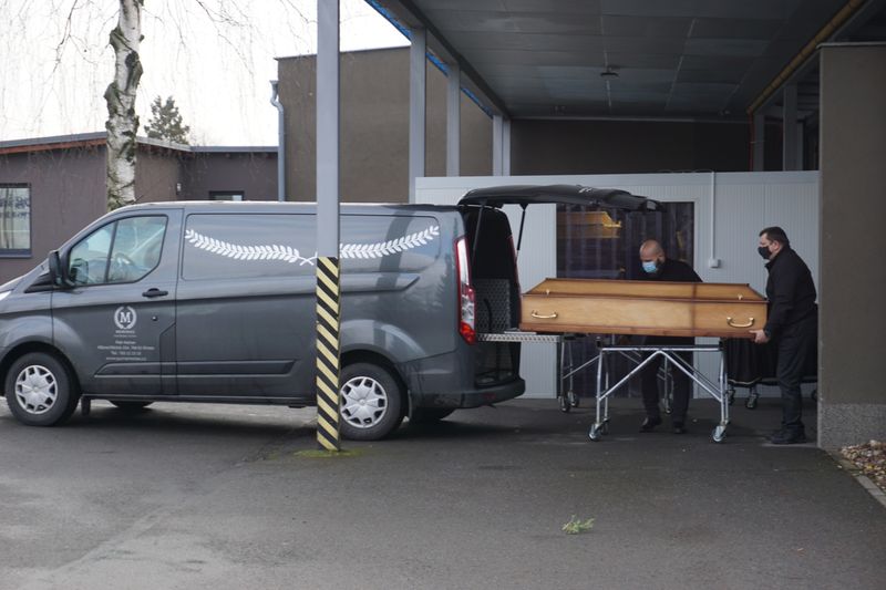 Funeral workers brings a coffin of a person who passed