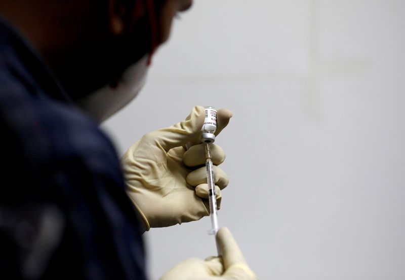 FILE PHOTO: A medic fills a syringe with COVAXIN, an