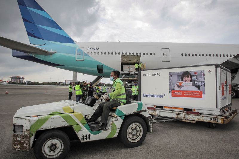 Staff arrange containers of COVID-19 vaccines at Soekarno-Hatta Airport