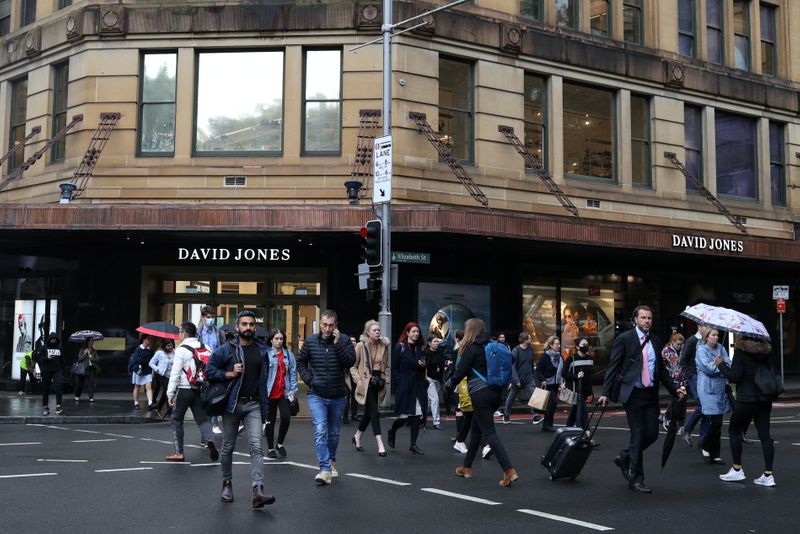 Pedestrians cross a street in the city centre of Sydney