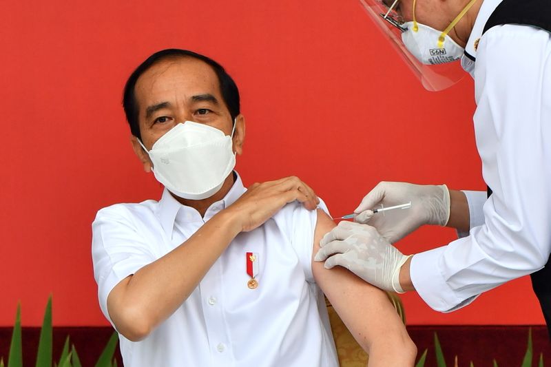 Indonesian President Joko Widodo receives a shot of COVID-19 vaccine