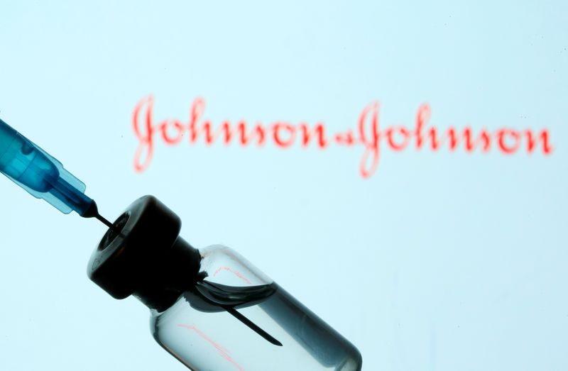 Vial and sryinge are seen in front of displayed Johnson&Johnson