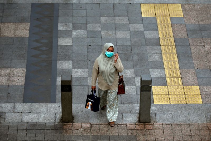 A woman wearing a protective mask walks on a sidewalk