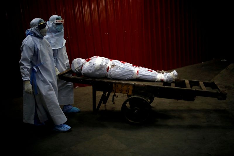 FILE PHOTO: Health workers carry the body of a man