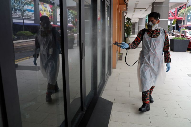 A firefighter sprays disinfectant at a business area, during a
