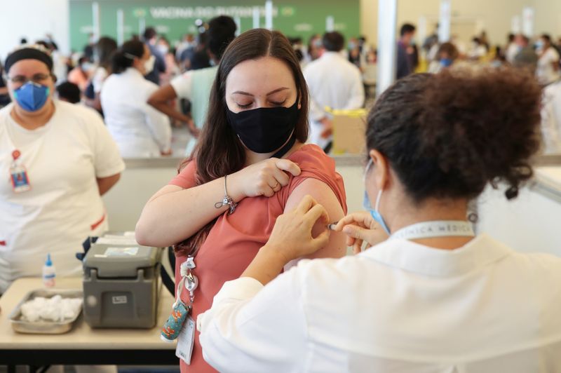 Healthcare workers receive vaccines at the Hospital das Clinicas in