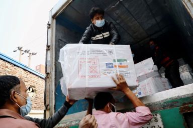Workers unload a pickup van that carries Oxford-Astrazeneca COVID-19 vaccines