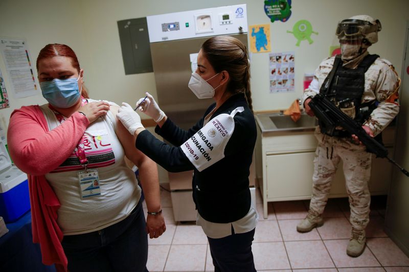 FILE PHOTO: A health worker receives an injection with a