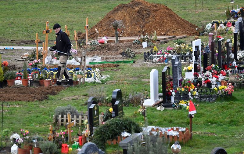 Workers dig graves at a cemetery in London