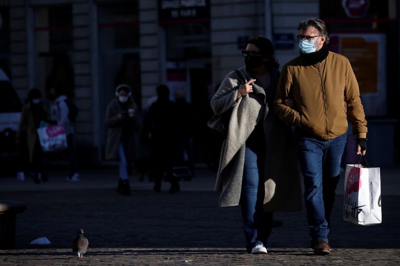 People, wearing protective face masks, walk in Nantes