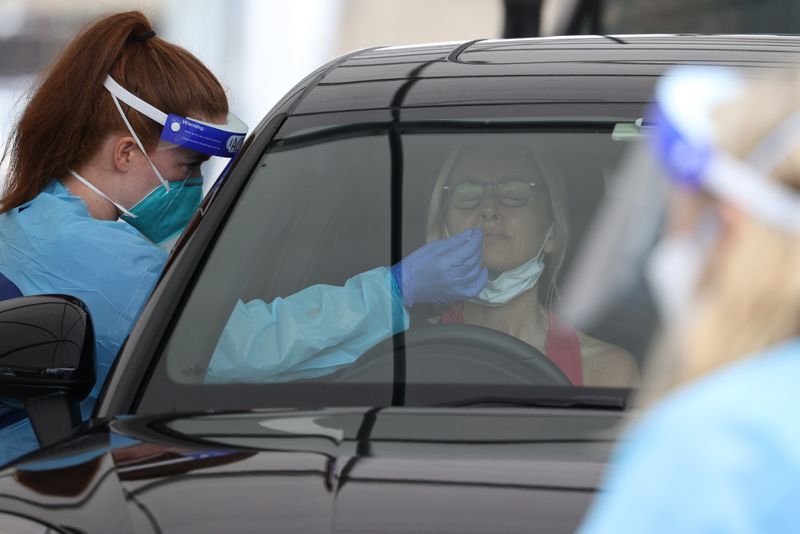 A medical worker swabs a member of the public at