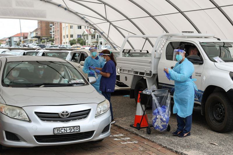 Medical workers administer tests at a drive-through COVID-19 testing centre