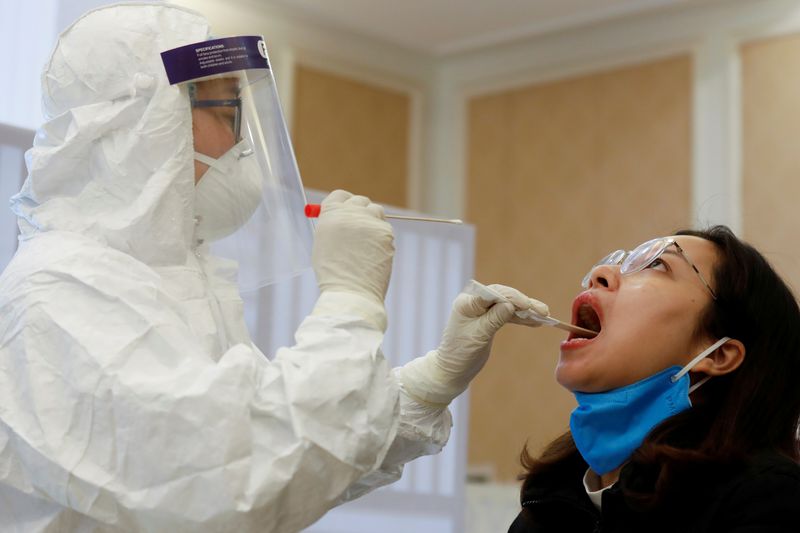 FILE PHOTO: A health worker takes a sample for a