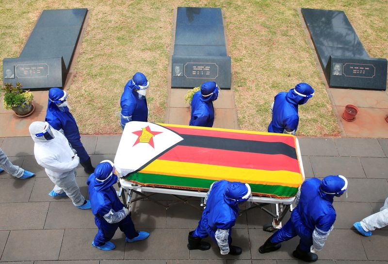 Pallbearers carry a coffin at the burial of two cabinet