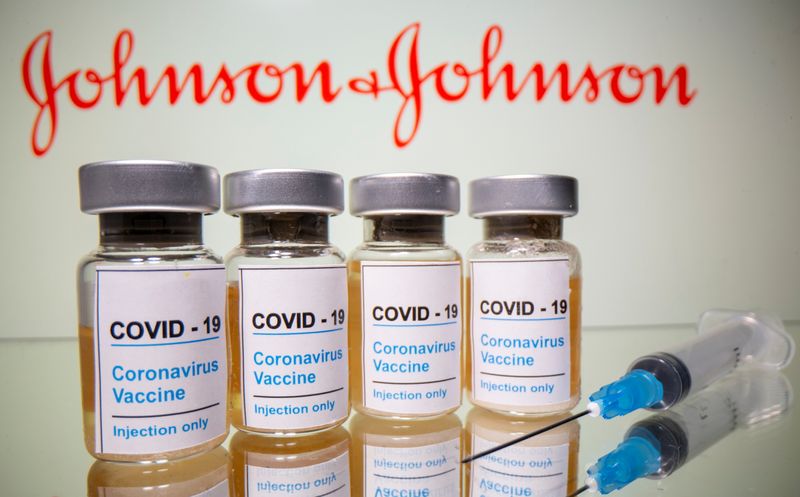 Vials and medical syringe are seen in front of J&J