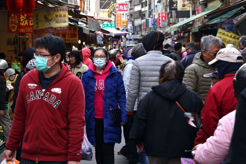 Customers wear protective masks while shopping at a market in