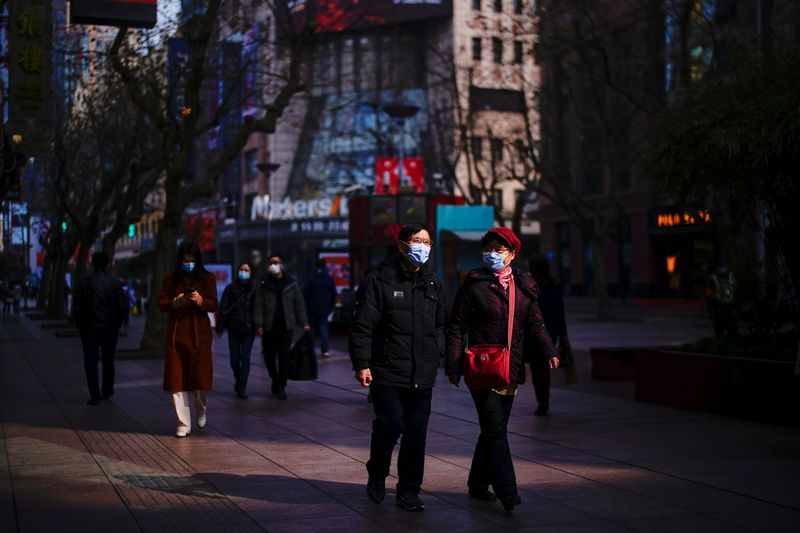 People wearing face masks walk at a main shopping area