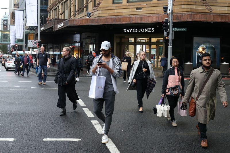Pedestrians cross a street in the city centre of Sydney