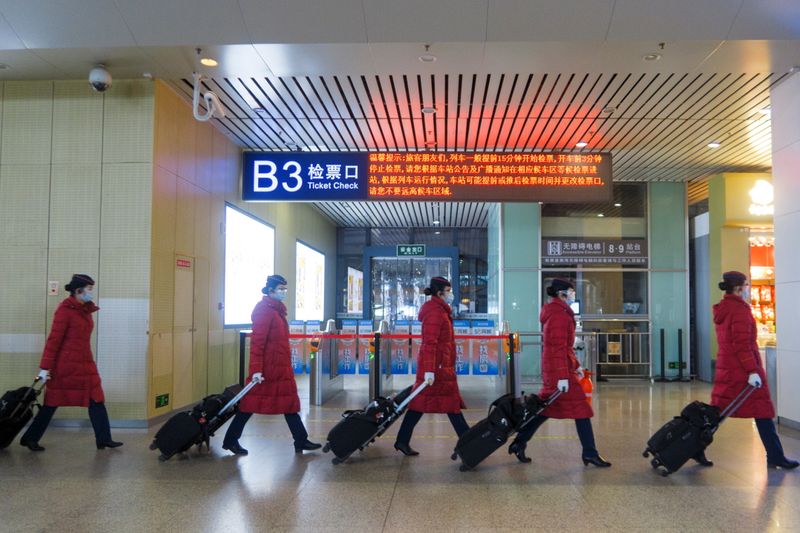 FILE PHOTO:Train attendants walk in Wuhan Railway Station following an