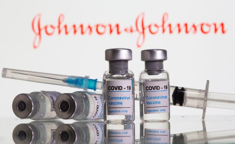 Vials labelled “COVID-19 Coronavirus Vaccine” and sryinge are seen in