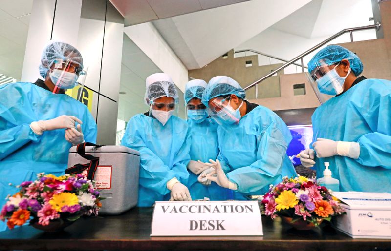 FILE PHOTO: Health officials prepare the AstraZeneca’s COVID-19 vaccines manufactured