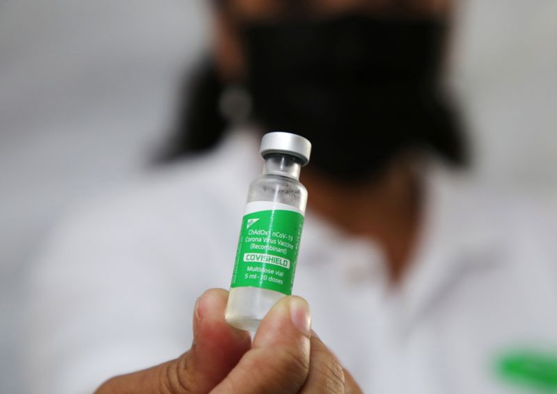 A health worker holds a vial with doses of the