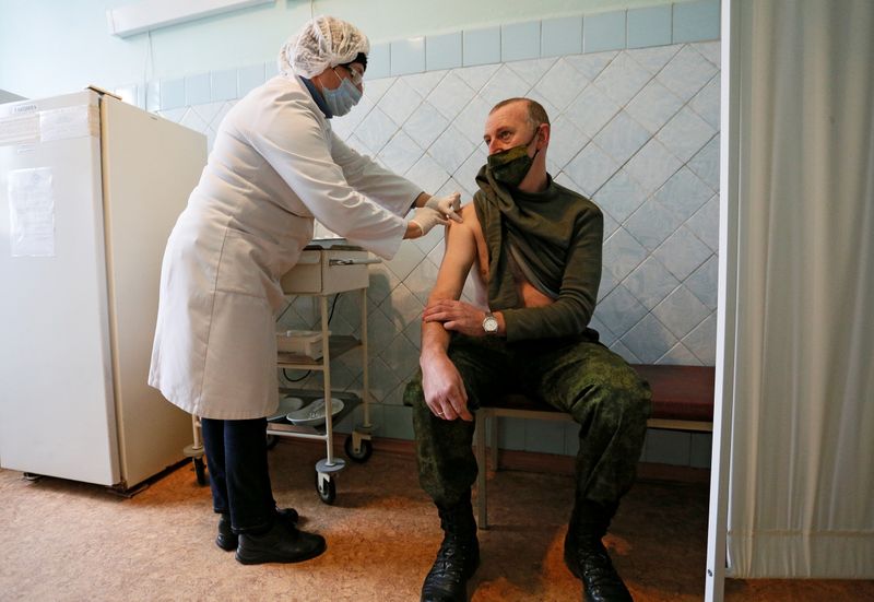 A serviceman receives a dose of Sputnik V vaccine against