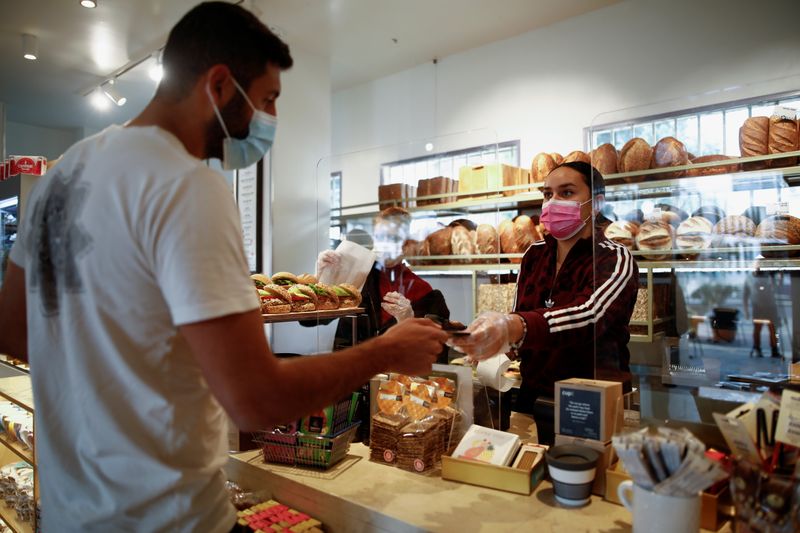 A customer pays at a cafe as Israel further eases