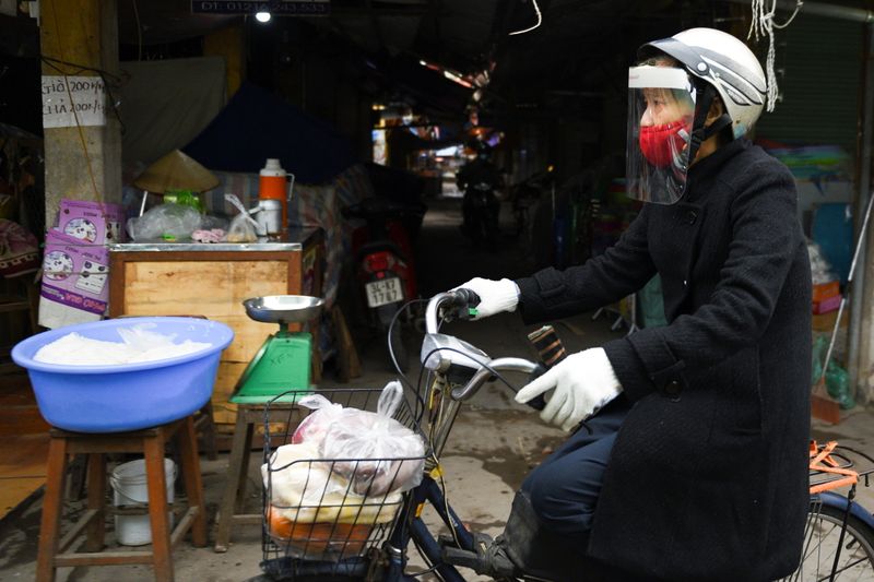 A woman wears a protective mask as she rides a