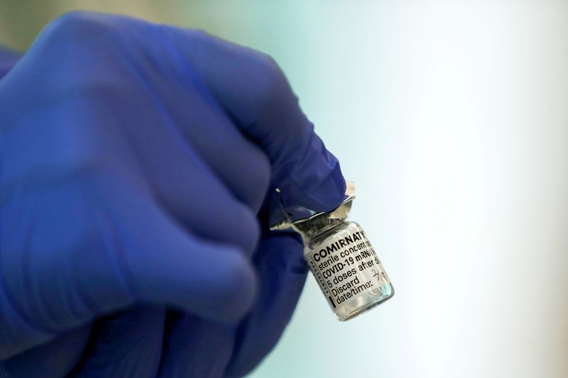 A medical worker holds a vial of the Pfizer-BioNTech coronavirus