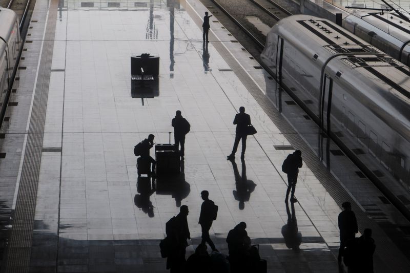People walk on a platform at Wuhan Railway Station following