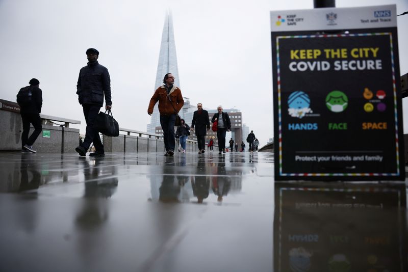 People walk over London Bridge during rush hour, amid the