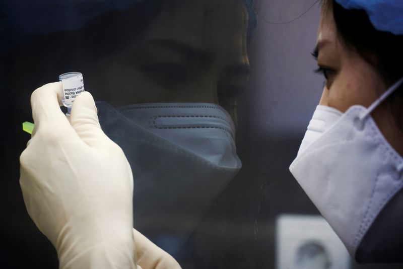 Registered nurse Kim Eun-suk measures a dose of the Pfizer-BioNTech