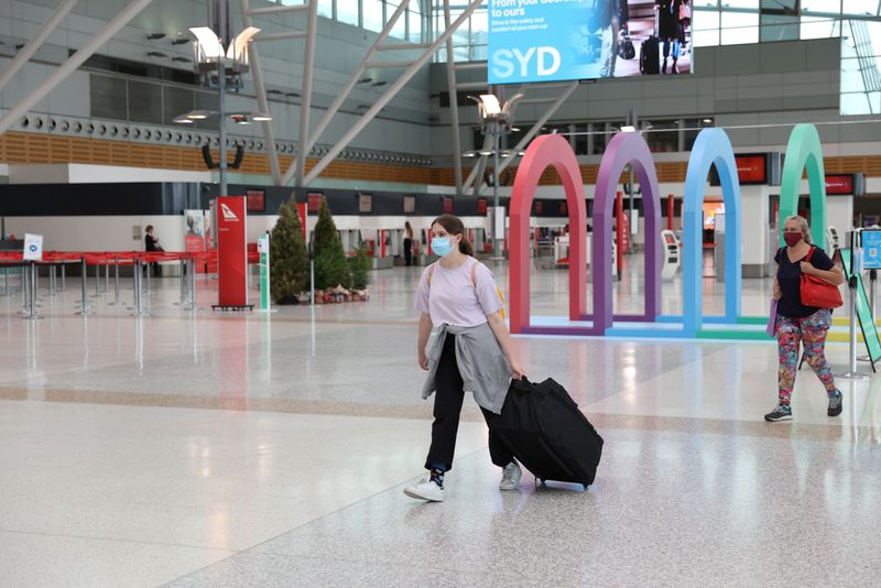 People wearing masks walk through Sydney Airport in the wake