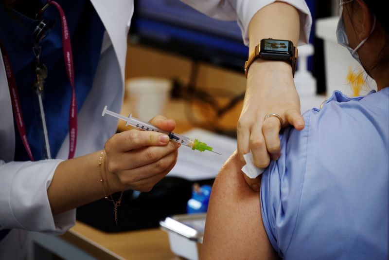 A health worker gets a dose of the Pfizer-BioNTech coronavirus