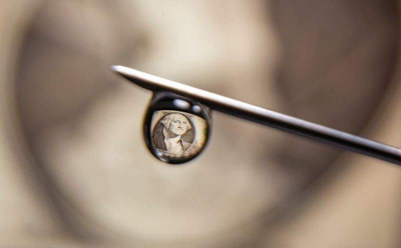 U.S. one dollar banknote is reflected in a drop on