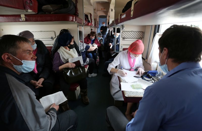 People wait to receive COVID-19 vaccine in a medical train in