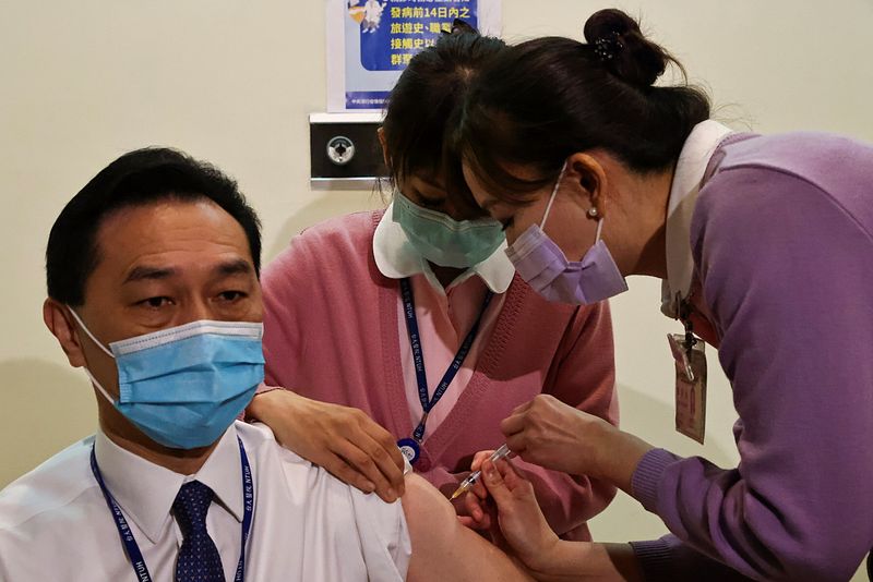A medical worker receives a dose of the AstraZeneca vaccine
