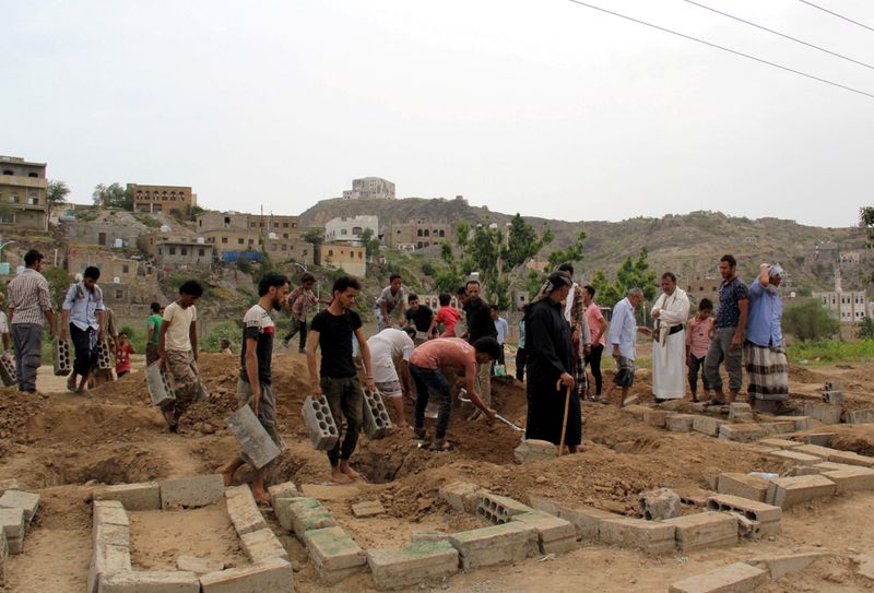 FILE PHOTO: People arrange a grave after a burial at