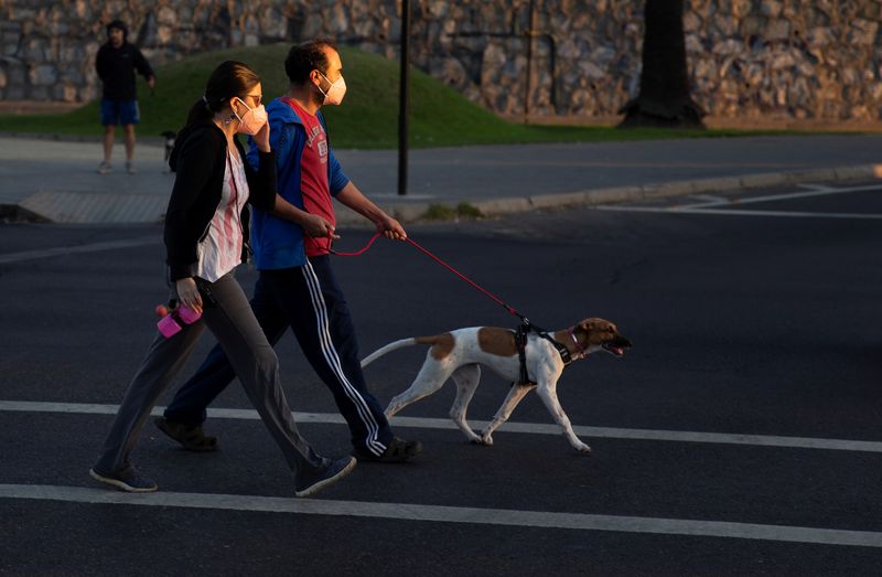 A couple walk their pet before night-time curfew announced by