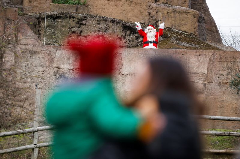 FILE PHOTO: A socially distanced Father Christmas waves at children