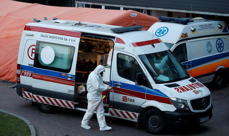 FILE PHOTO: A paramedic walks near an ambulance amid the
