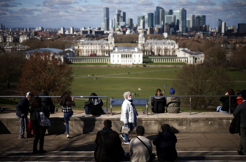 People gather at a viewpoint in Greenwich Park, amid the