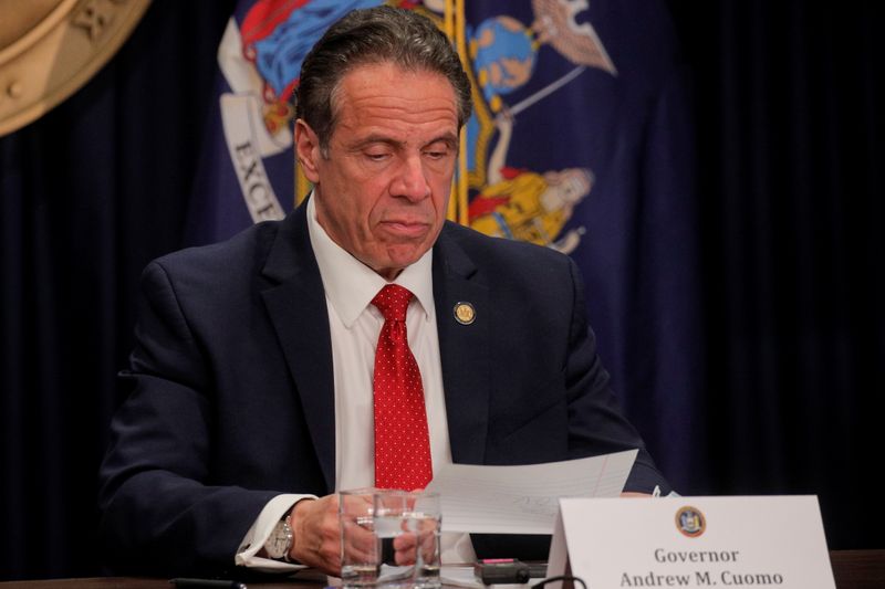 New York Governor Andrew Cuomo reads a note during a