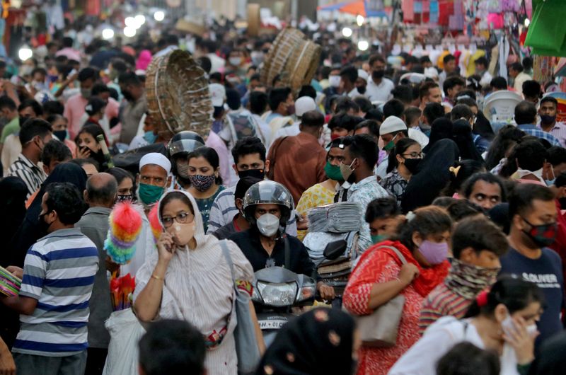 FILE PHOTO: People wearing protective masks crowd a marketplace amidst