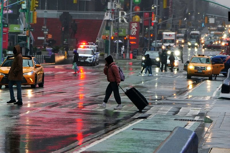 People walk in the rain in Times Square in New
