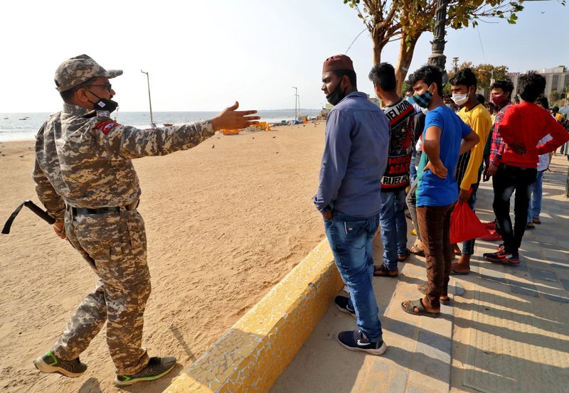 A policeman asks people to leave Juhu beach to prevent
