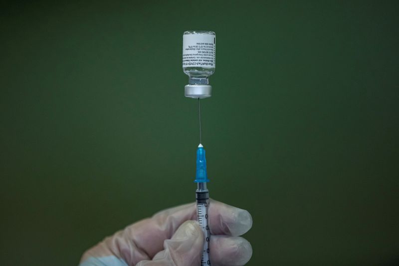 FILE PHOTO: A medical worker fills a syringe with Pfizer-BioNTech