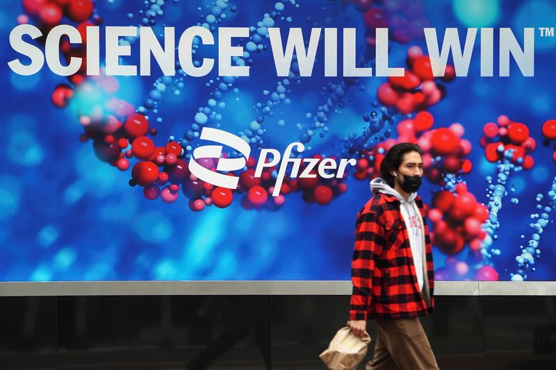 A person walks past a Pfizer sign in New York