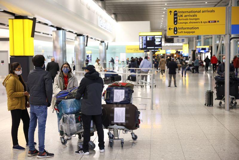 FILE PHOTO: Travellers walk through Terminal 2 at Heathrow Airport,